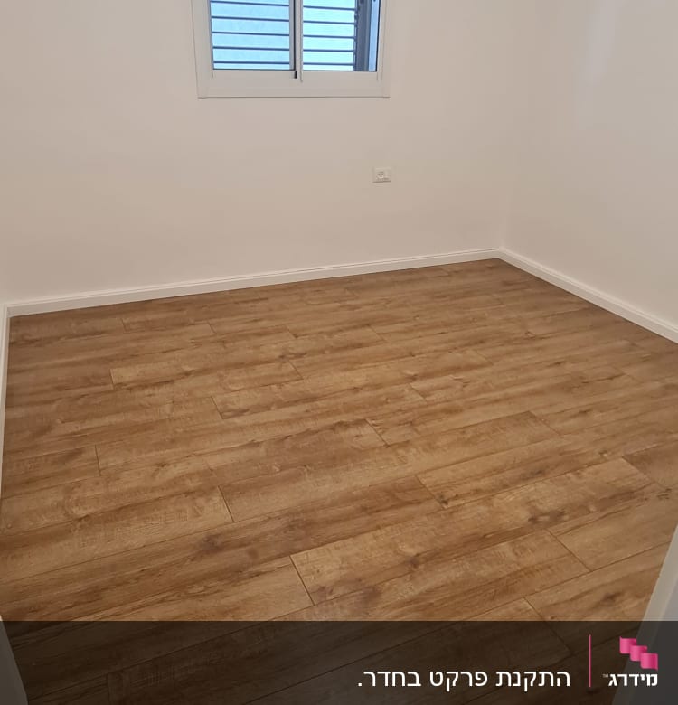 רצפת פרקט עץ בחדר ריק עם קירות לבנים